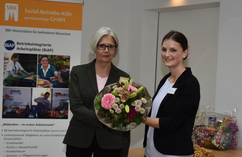SBK-Geschäftsführerin Gabriele Patzke überreicht Fachdienstleiterin Sophia Thomas einen Blumenstrauß.