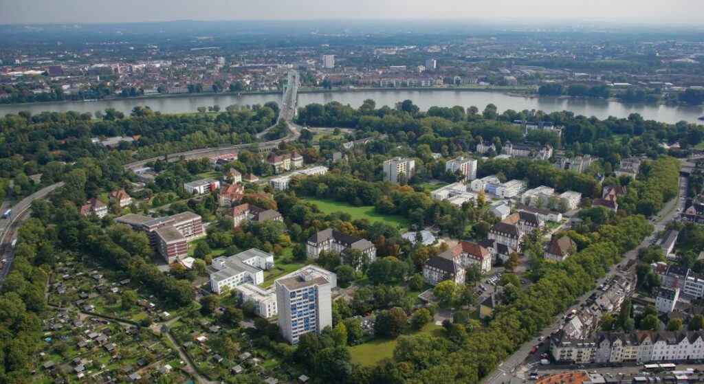 Luftbild des Riehler SBK-Geländes – im Hintergrund der Rhein und der Kölner Stadtteil Mülheim.